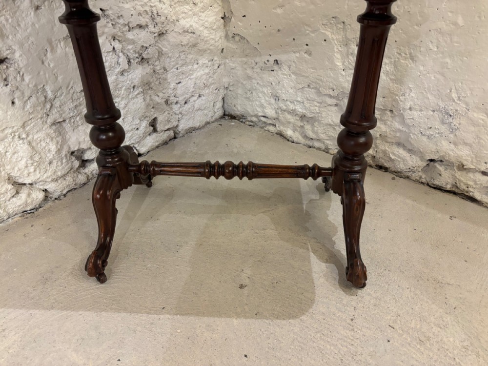 A Victorian mahogany library table featuring a rectangular polished top with rounded corners, supported by turned end pillars and a central stretcher base. View II