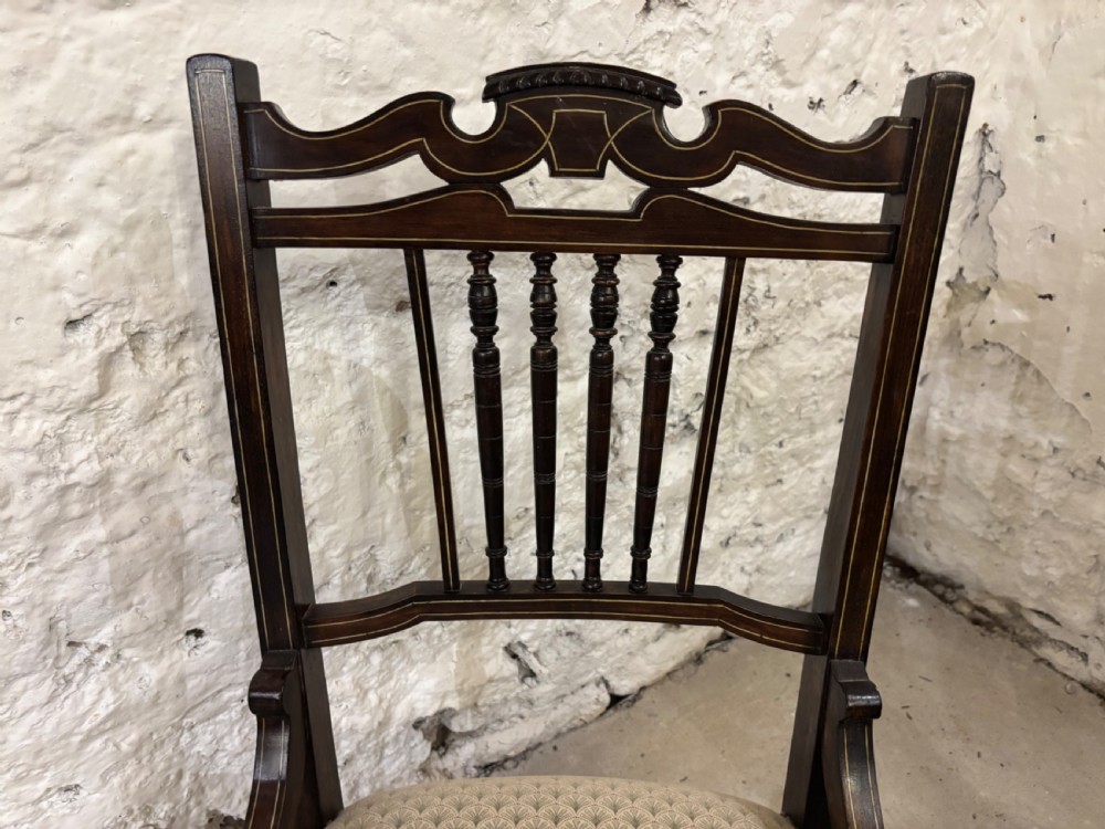 Pair of late Victorian dark wood nursing chairs featuring one spindle-back chair with cream patterned fabric and one oval-back chair upholstered in mustard yellow velvet. View V