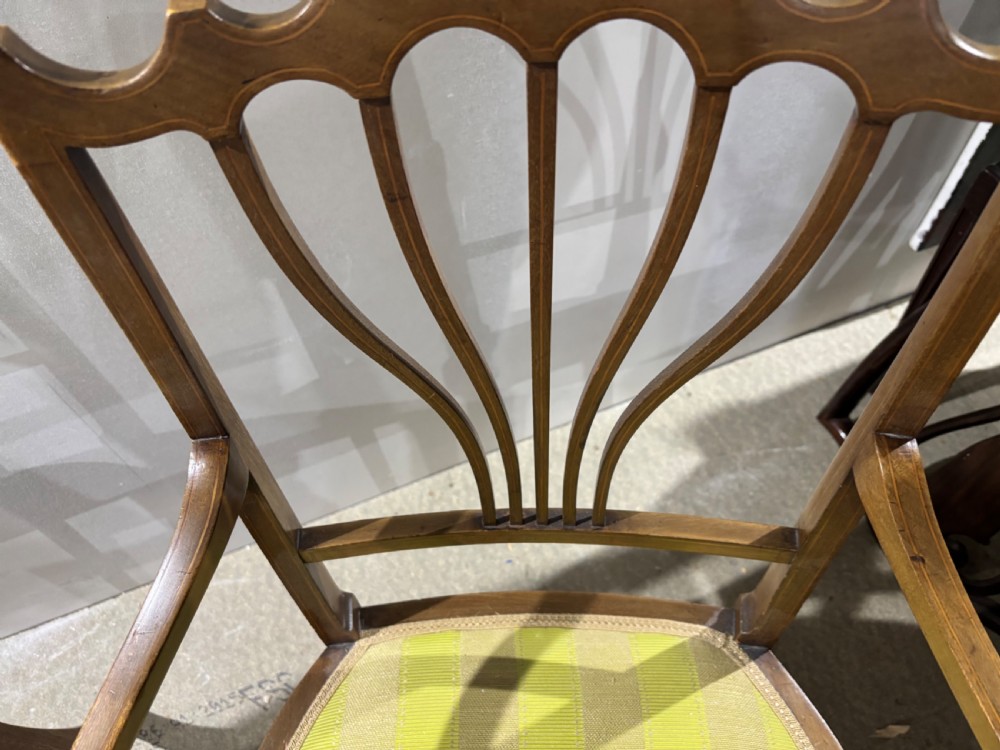 A set of four Edwardian mahogany salon chairs featuring fan-shaped pierced back splats, subtle string inlay, slender tapered legs, and yellow striped fabric seat cushions. View IV