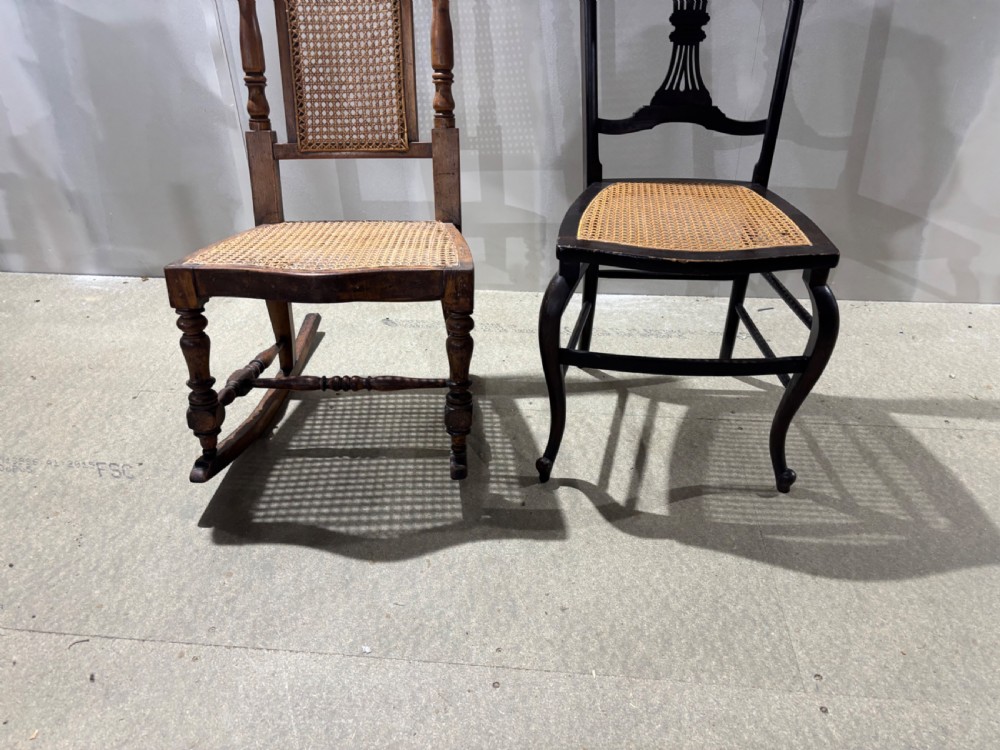 Two late Victorian chairs featuring woven cane seats, one a rocking chair with a cane back panel and turned frame, the other a dark side chair with a carved back rest. View IV