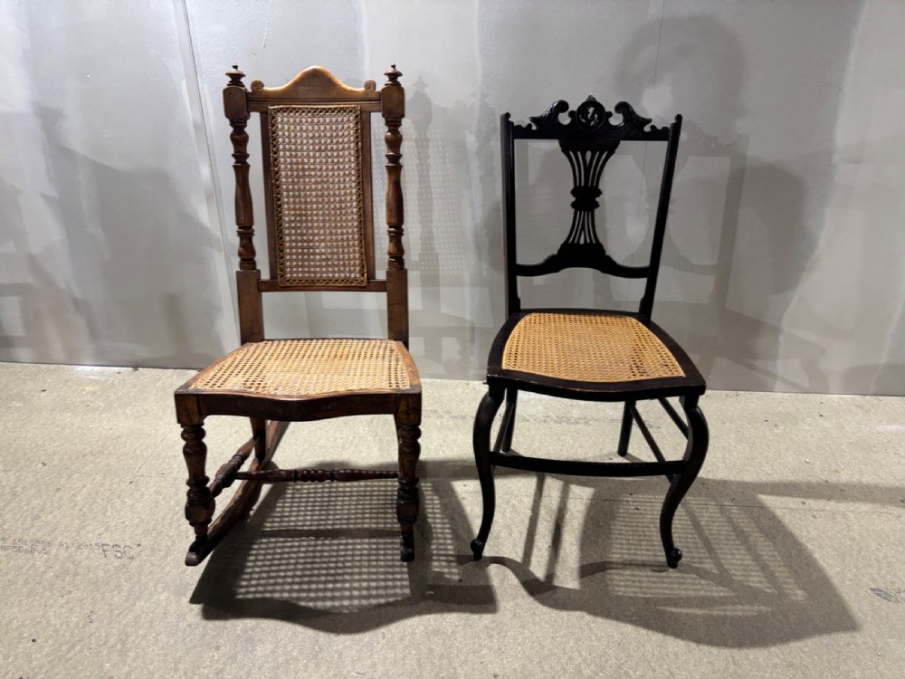 Two late Victorian chairs featuring woven cane seats, one a rocking chair with a cane back panel and turned frame, the other a dark side chair with a carved back rest. View V