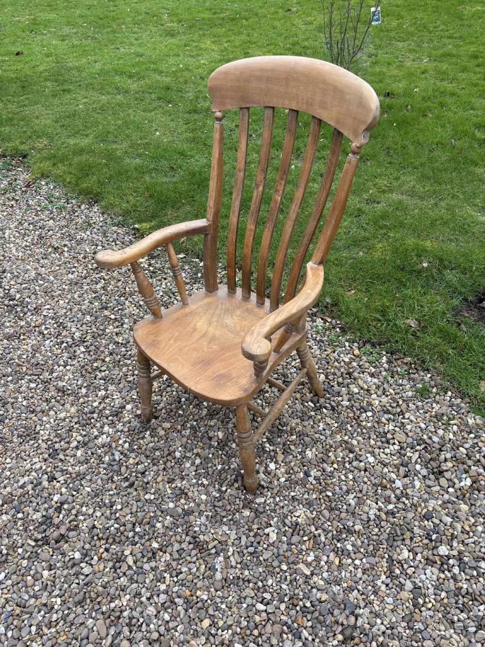 A Victorian ash and elm lath back armchair featuring vertical back slats, shaped armrests, a solid saddle seat, and turned wooden legs. View III