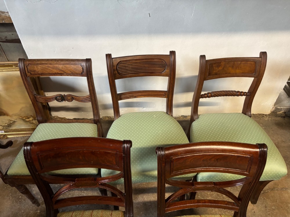 A group of six antique Regency mahogany and rosewood dining chairs featuring carved back rails, turned legs, upholstered seats, and a woven cane seat. View VI