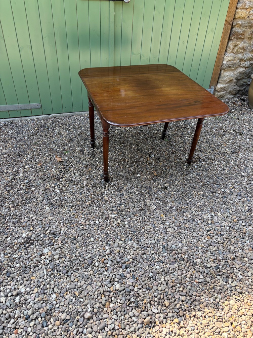 A Victorian mahogany Pembroke table with extended drop leaves and turned wood legs.