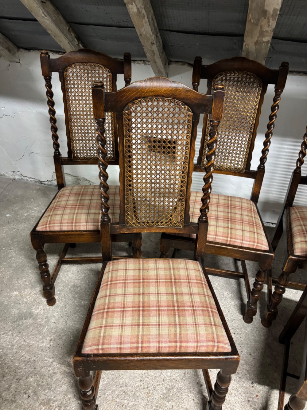 A set of six dark oak dining chairs with cane-panelled backs, barley twist uprights, turned legs, and plaid fabric upholstered seats. View V