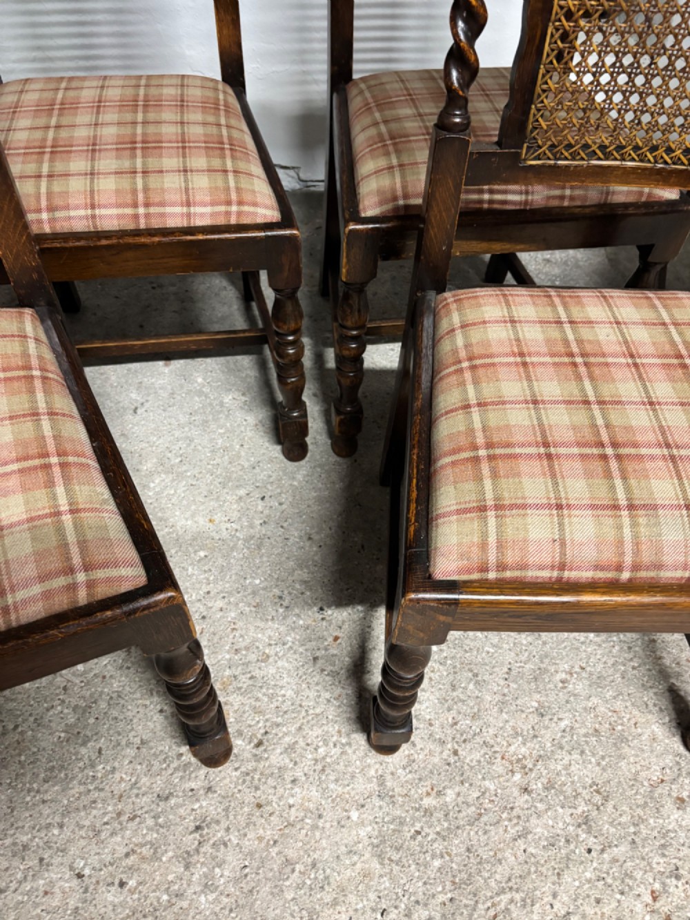 A set of six dark oak dining chairs with cane-panelled backs, barley twist uprights, turned legs, and plaid fabric upholstered seats. View VII