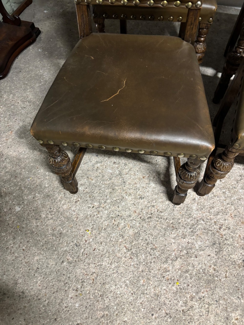 A set of eight oak dining chairs featuring arched olive leather backs and seats trimmed with brass studding. View V