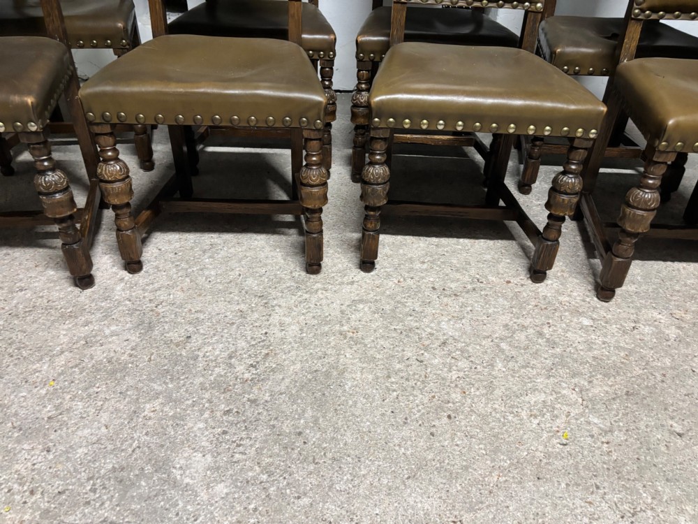 A set of eight oak dining chairs featuring arched olive leather backs and seats trimmed with brass studding. View VI