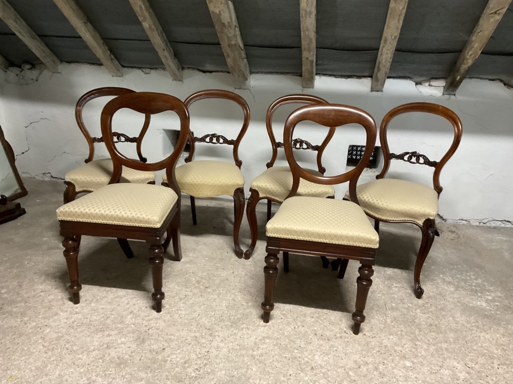 A set of six Victorian balloon back dining chairs in dark wood with cream patterned upholstered seats. View II