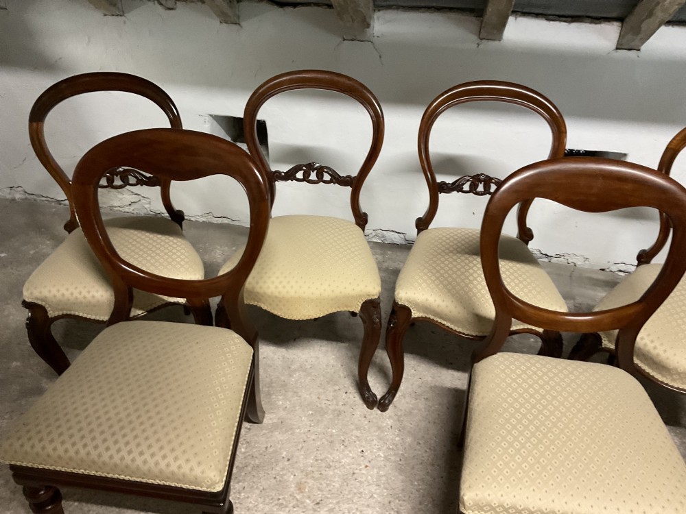 A set of six Victorian balloon back dining chairs in dark wood with cream patterned upholstered seats. View V
