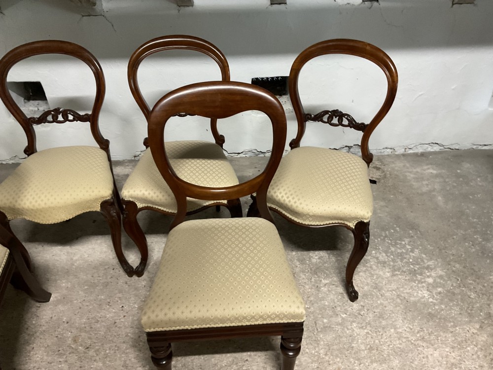A set of six Victorian balloon back dining chairs in dark wood with cream patterned upholstered seats. View VI