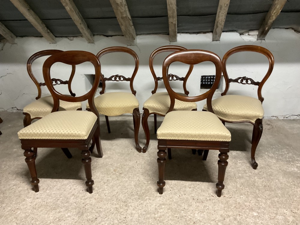 A set of six Victorian balloon back dining chairs in dark wood with cream patterned upholstered seats. View VII