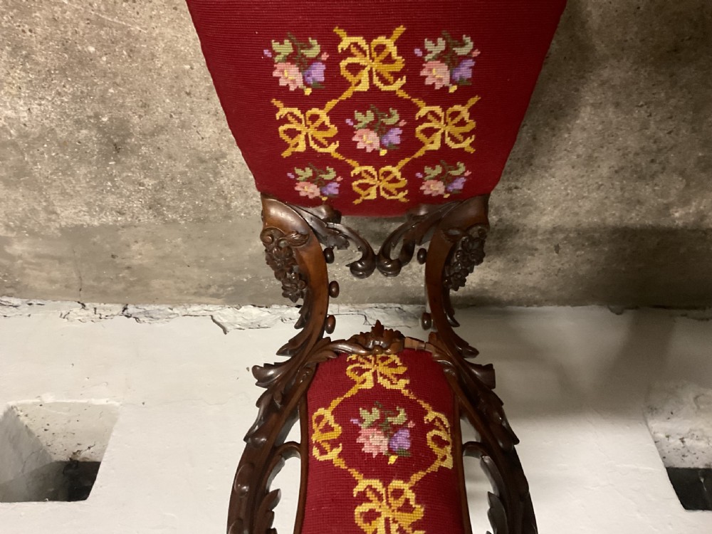 A 19th-century carved mahogany hall chair featuring an openwork backrest, cabriole legs, and crimson tapestry upholstery with floral needlepoint. View IV