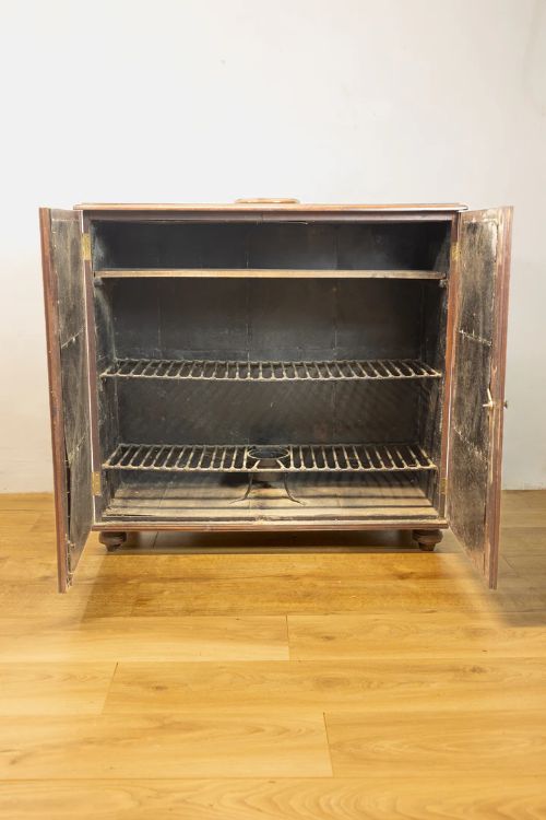 fig 2. A warm brown mahogany two-door naval campaign cabinet with side brass carrying handles and turned feet.