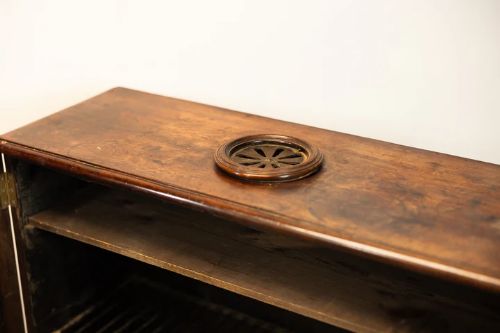 fig 3. A warm brown mahogany two-door naval campaign cabinet with side brass carrying handles and turned feet.