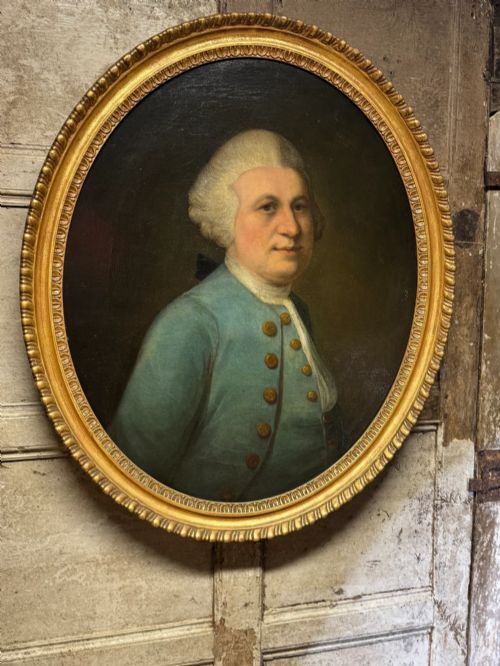 fig 3. An 18th-century oval oil portrait depicting a gentleman in a blue coat and wig, set inside a carved giltwood frame.