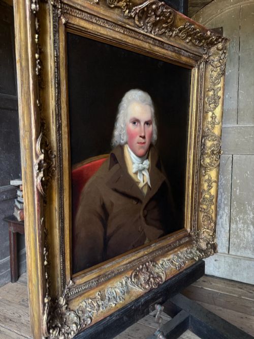 fig 1. An 18th-century oil painting on canvas depicting a gentleman in a brown coat and white cravat, housed in a thick, ornate gilded frame.