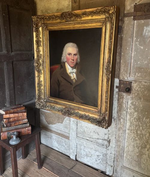 fig 2. An 18th-century oil painting on canvas depicting a gentleman in a brown coat and white cravat, housed in a thick, ornate gilded frame.
