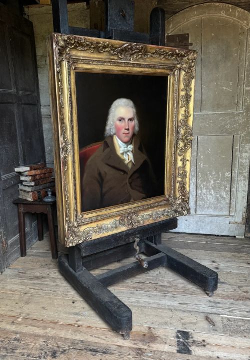 fig 3. An 18th-century oil painting on canvas depicting a gentleman in a brown coat and white cravat, housed in a thick, ornate gilded frame.