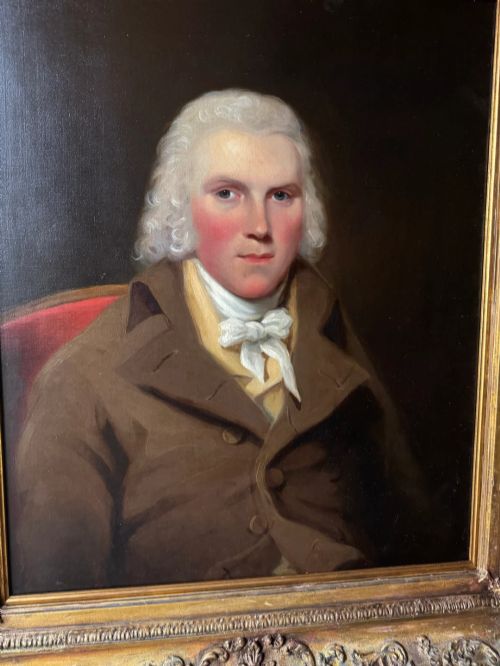 fig 5. An 18th-century oil painting on canvas depicting a gentleman in a brown coat and white cravat, housed in a thick, ornate gilded frame.