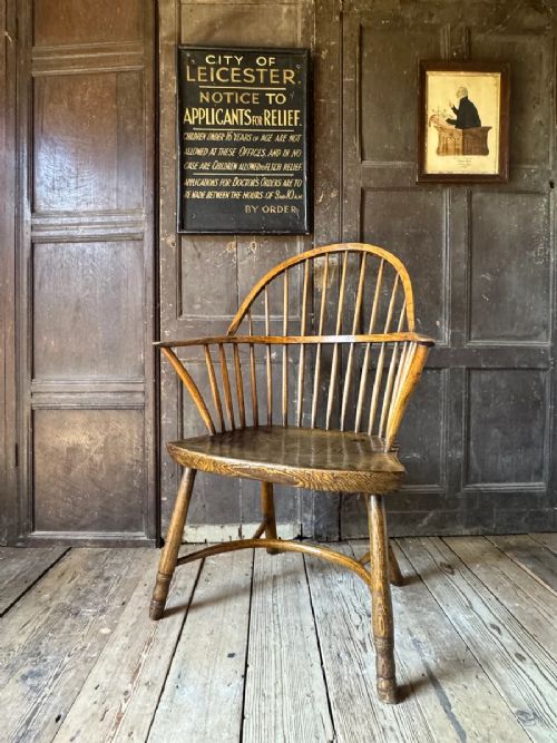 fig 1. A George III West Country Windsor armchair made of elm and ash wood, featuring a spindled backrest, shaped timber seat, turned legs, and a cow-horn stretcher.