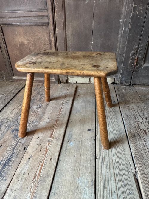 fig 1. An early 19th-century rustic wooden stool featuring a rectangular sycamore seat top with visible wedged through-tenons and four splayed ash legs.