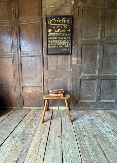 fig 2. An early 19th-century rustic wooden stool featuring a rectangular sycamore seat top with visible wedged through-tenons and four splayed ash legs.