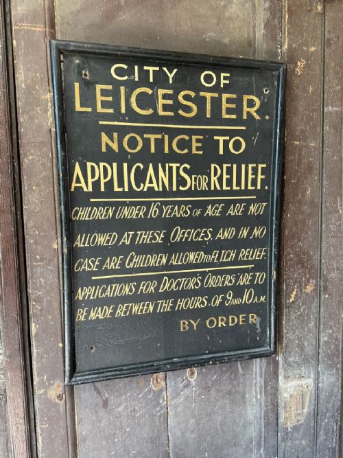 fig 1. A black rectangular wooden notice sign framed in timber featuring gilded hand-painted lettering with instructions for the City of Leicester.
