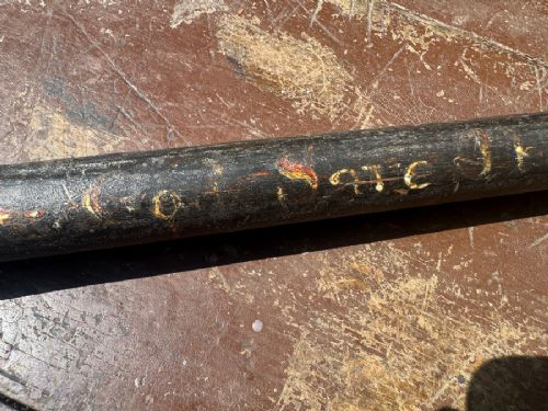 fig 1. A dark turned wooden George III cudgel featuring hand-painted lettering that reads God Save The King.