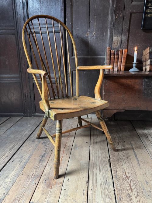 fig 2. A George III high hoop-back Windsor armchair crafted from elm and ash with turned legs and a carved timber seat.