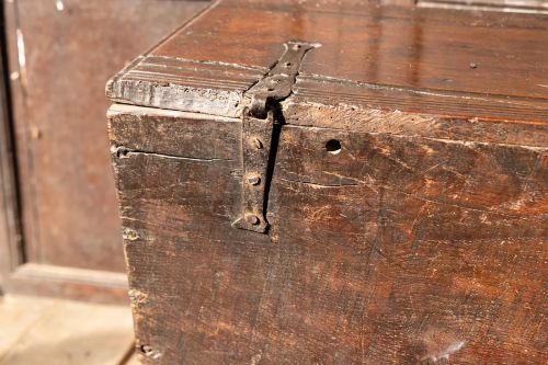 fig 9. An Elizabethan carved oak boarded chest featuring relief carvings of winged mythical beasts, an iron lockplate, and slab end legs.