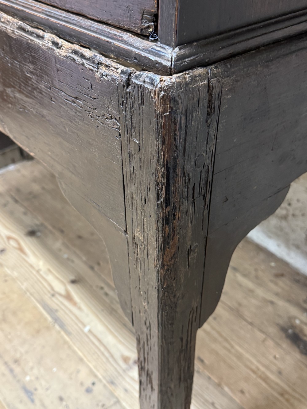 A George III provincial dark wood linen press with a turned screw mechanism mounted above a single drawer base on square legs. View X