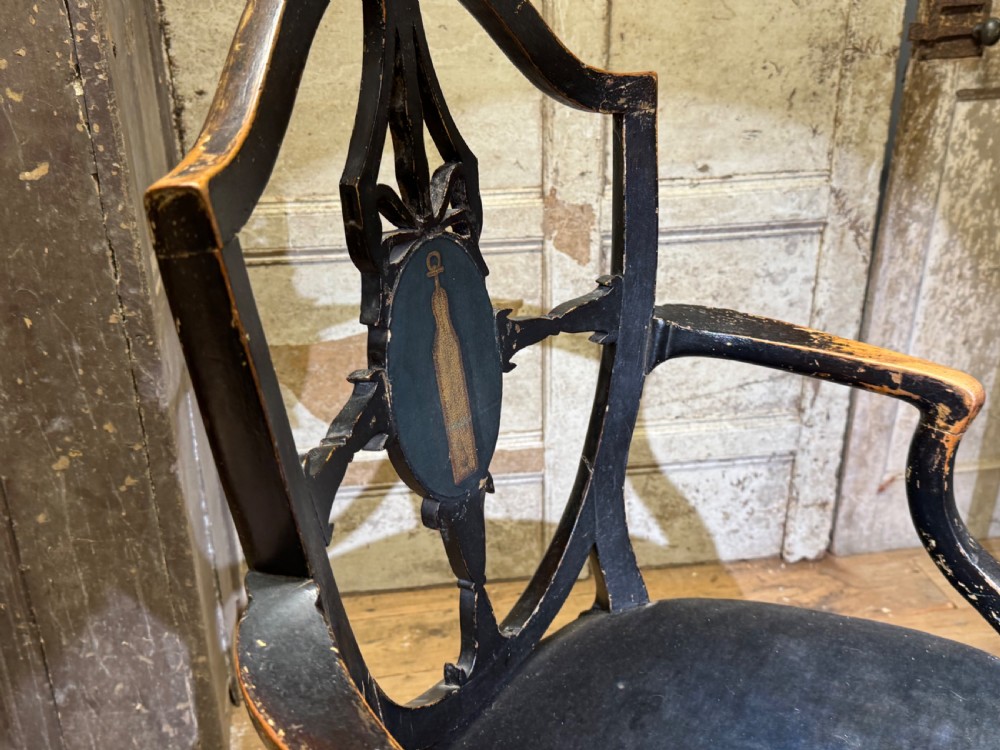 A late eighteenth-century George III black painted armchair featuring an open decorative backrest, curved arms, dark velvet upholstery, and square block feet. View III