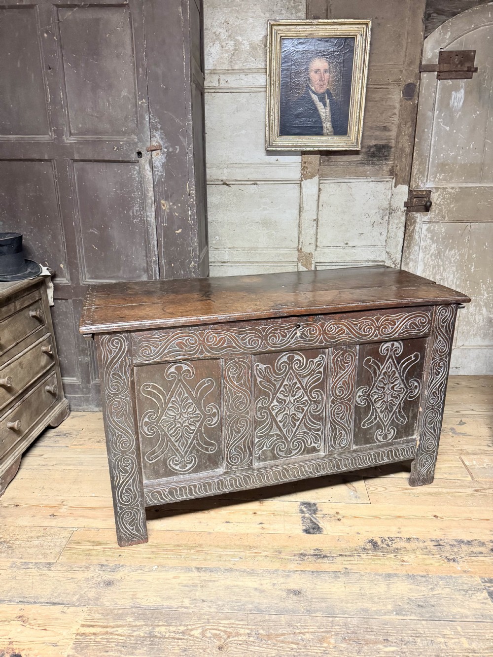 A 17th-century joined oak coffer featuring three carved lozenge panels and decorative carved stiles. View IV