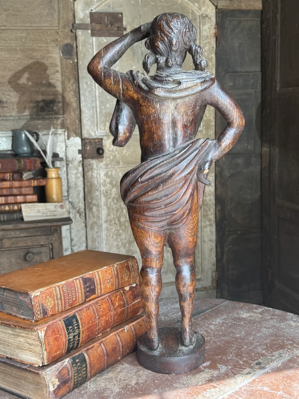 An 18th-century carved oak standing male figure with drapery across his shoulder set on a rounded base. View IV