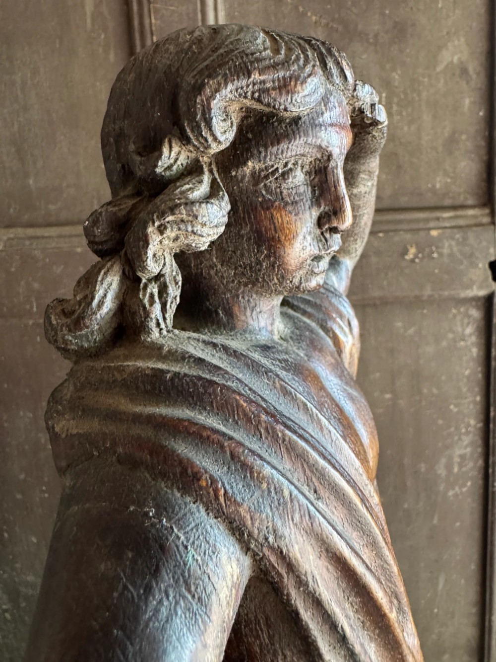 An 18th-century carved oak standing male figure with drapery across his shoulder set on a rounded base. View VI