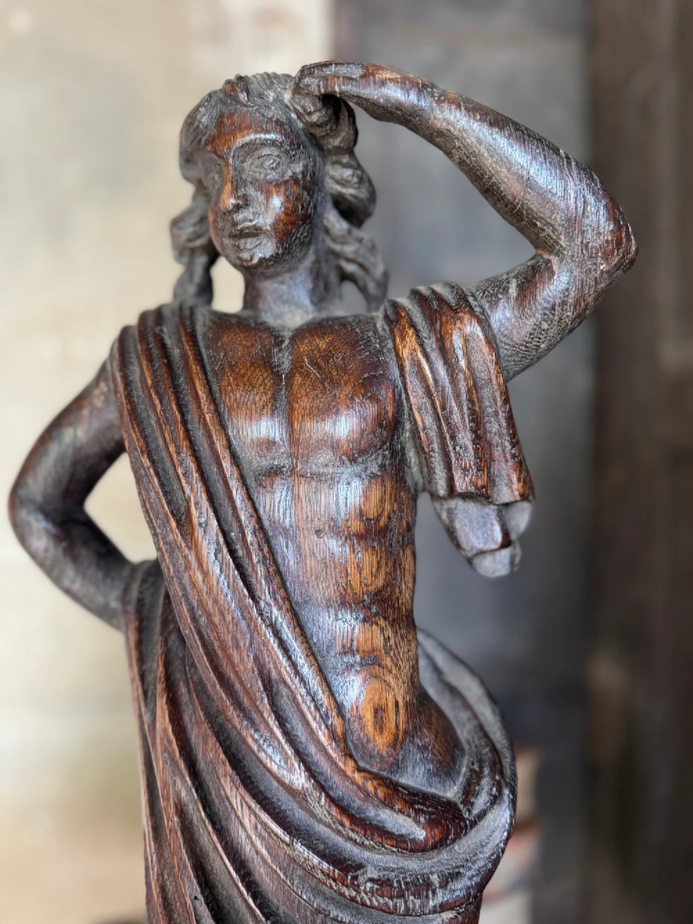 An 18th-century carved oak standing male figure with drapery across his shoulder set on a rounded base. View XII