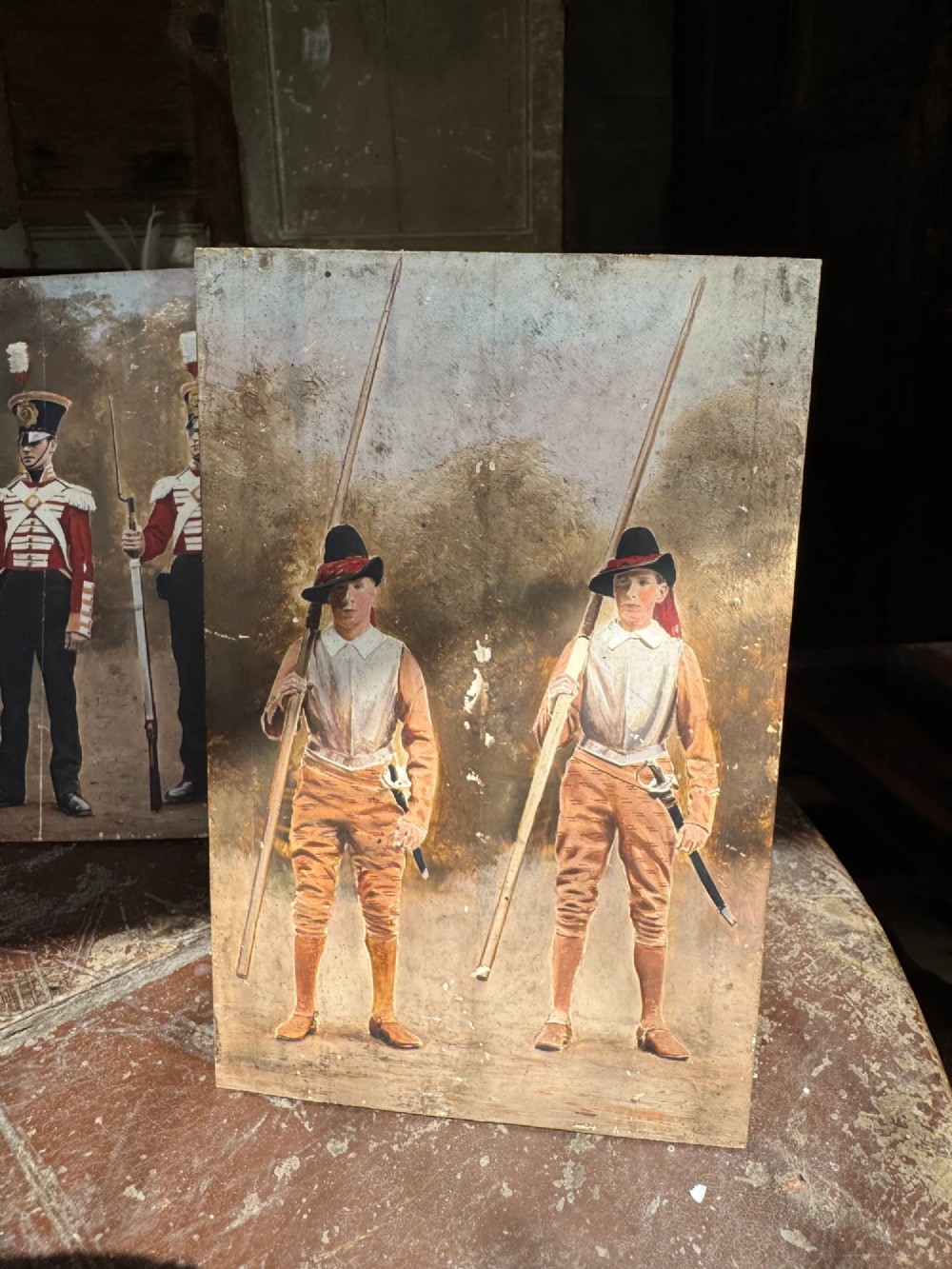 A set of four early twentieth-century wooden panels featuring hand-painted depictions of military soldiers in red uniform coats. View VI