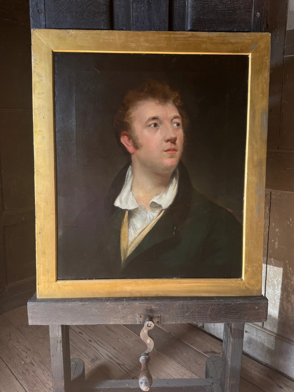 An early 19th-century oil portrait depicting a fair-skinned gentleman with reddish hair in a dark green coat, set inside a gilded wooden frame.