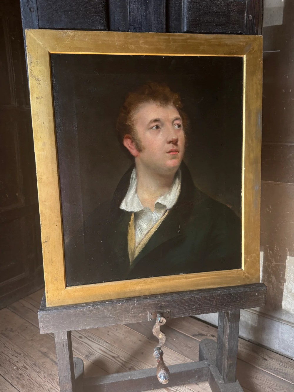 An early 19th-century oil portrait depicting a fair-skinned gentleman with reddish hair in a dark green coat, set inside a gilded wooden frame. View II
