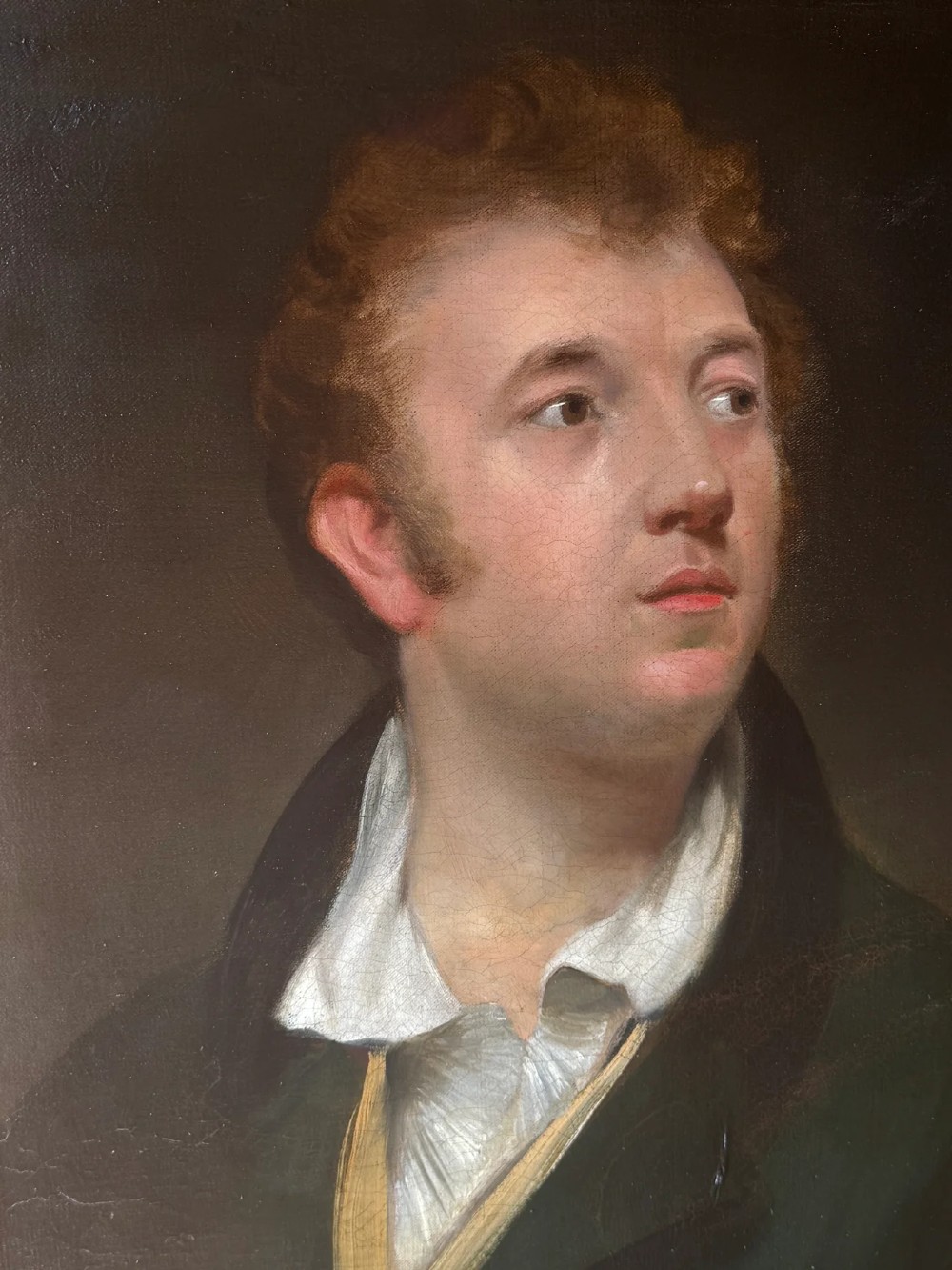 An early 19th-century oil portrait depicting a fair-skinned gentleman with reddish hair in a dark green coat, set inside a gilded wooden frame. View IV