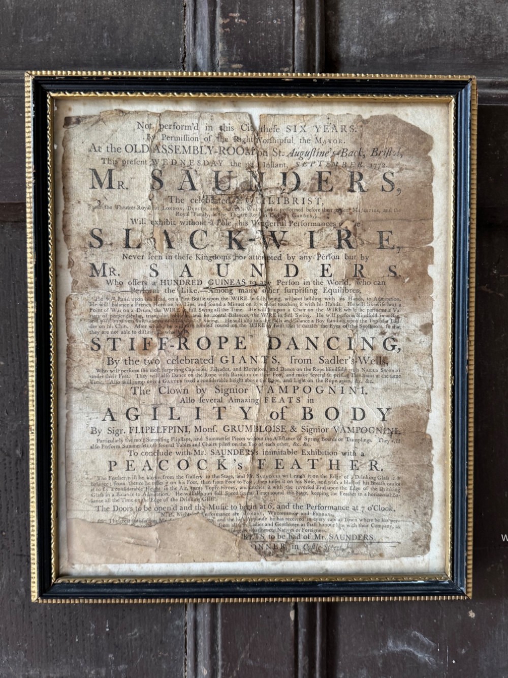 An 18th-century paper handbill with black letterpress typography advertising performance acts, displayed in a black frame with a gilt inner border.