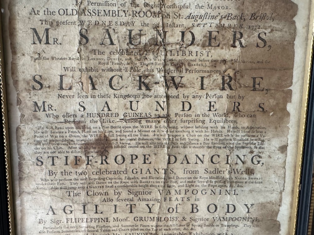 An 18th-century paper handbill with black letterpress typography advertising performance acts, displayed in a black frame with a gilt inner border. View III