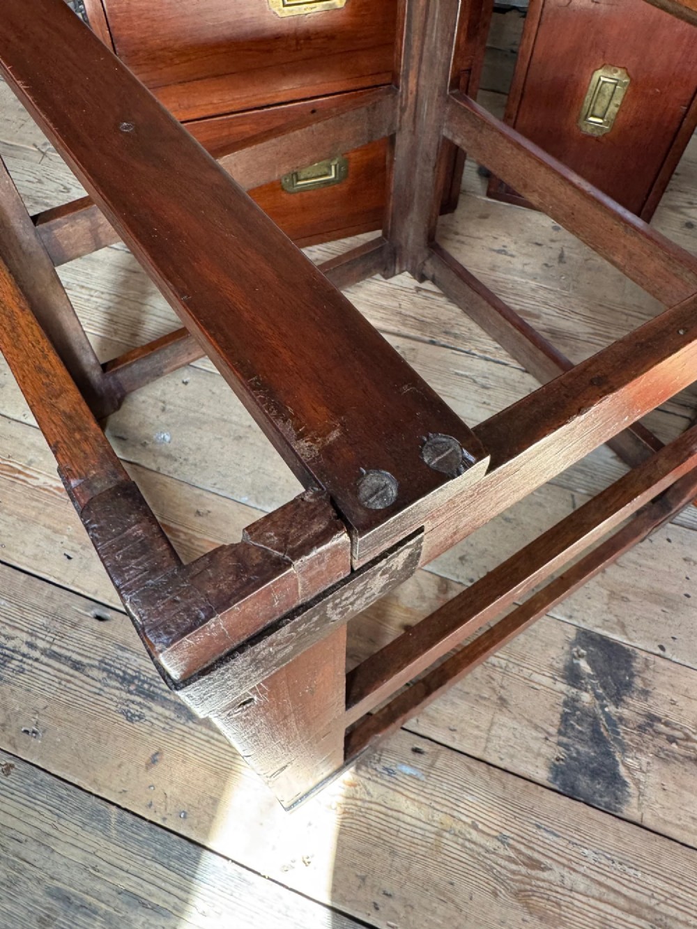 Late 19th-century Anglo-Indian campaign desk crafted from rich reddish-brown timber with flush brass handles and open frame bases. View X