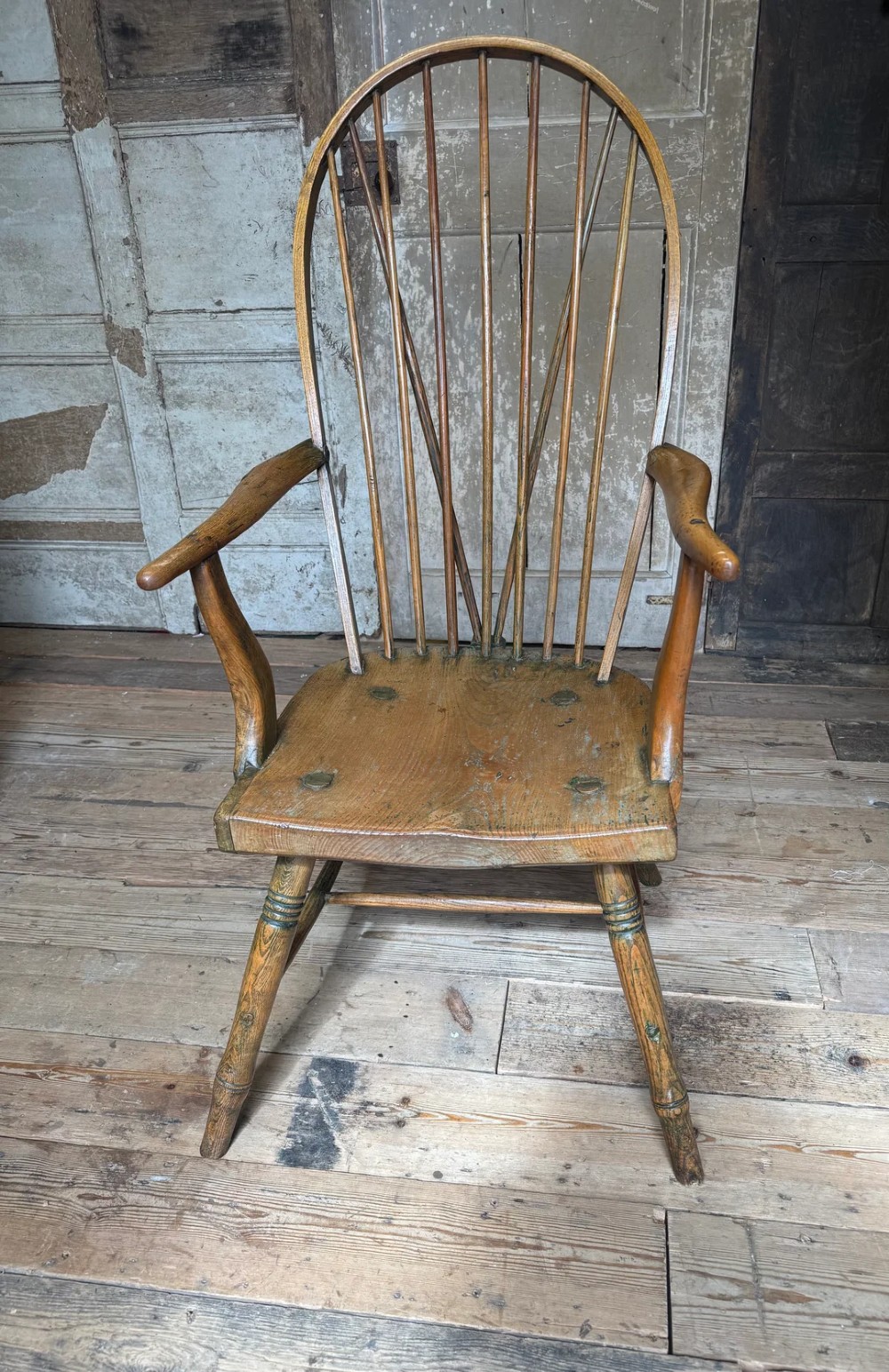 A George III high hoop-back Windsor armchair crafted from elm and ash with turned legs and a carved timber seat. View IV