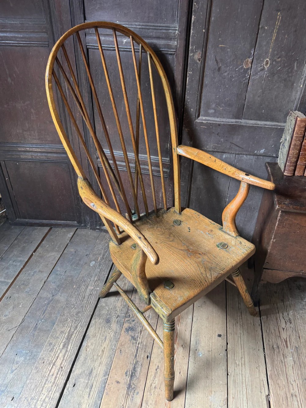A George III high hoop-back Windsor armchair crafted from elm and ash with turned legs and a carved timber seat. View XI