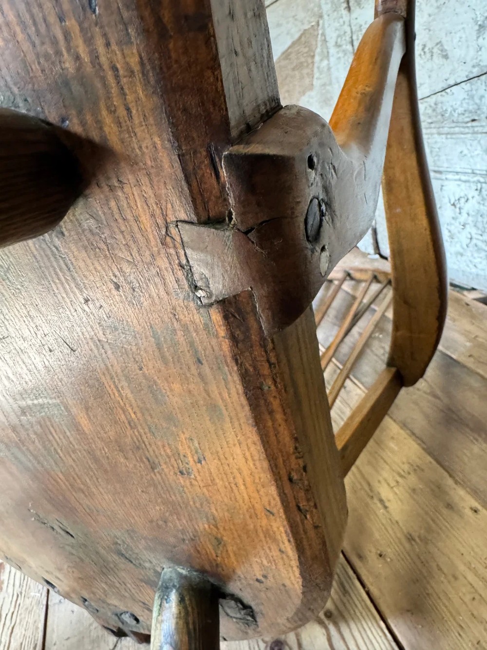 A George III high hoop-back Windsor armchair crafted from elm and ash with turned legs and a carved timber seat. View XV