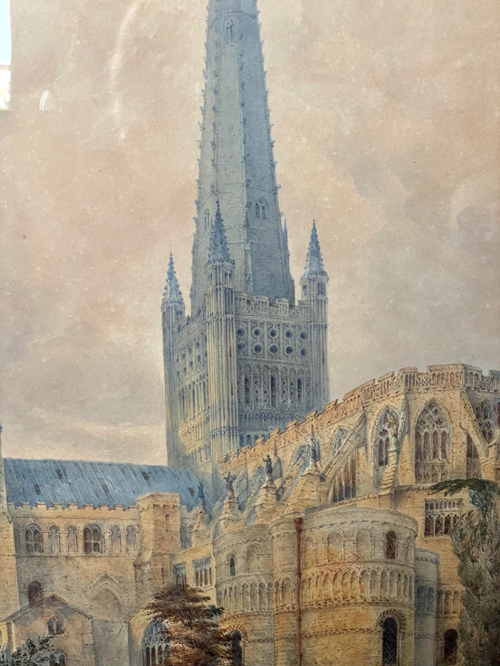 A nineteenth-century watercolour painting depicting Norwich Cathedral with a detailed spire, flying buttresses, and figures on the surrounding lawn. View VII