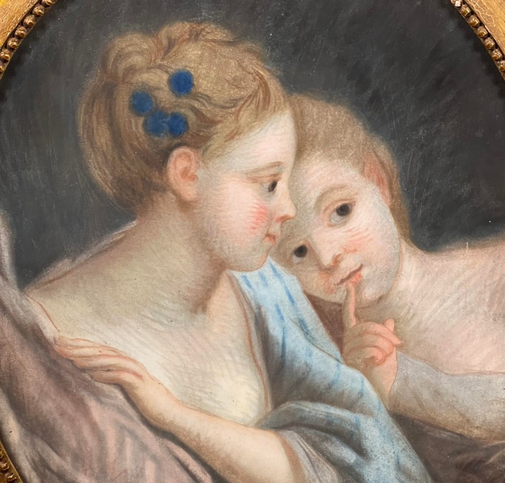 An oval gilt-framed antique pastel portrait depicting two young ladies with draped fabric against a dark background. View II