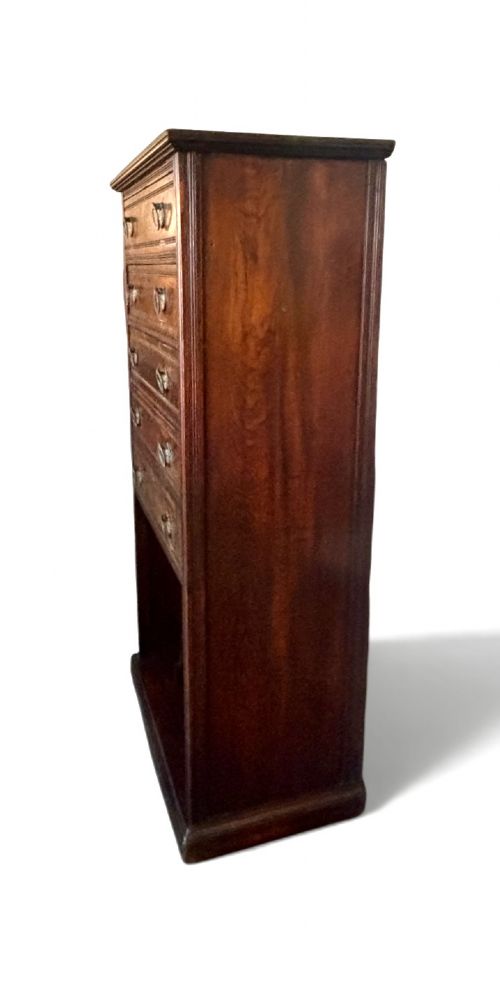 An early 20th-century tall and narrow mahogany chest featuring five drawers over an open lower section with vertical dividers. View II